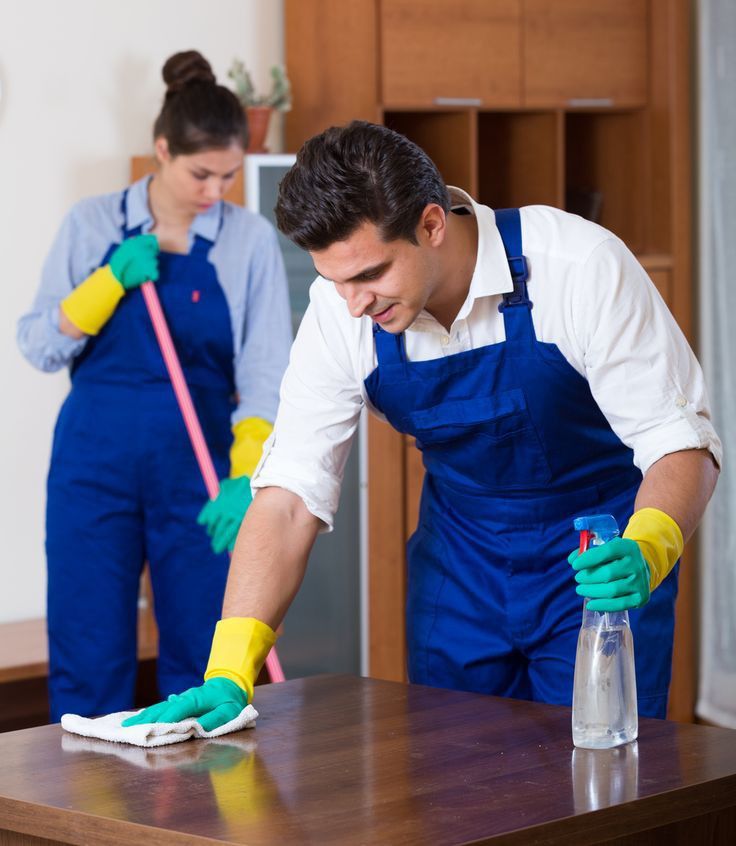 Two-person crew cleaning and prepping a furnished room
