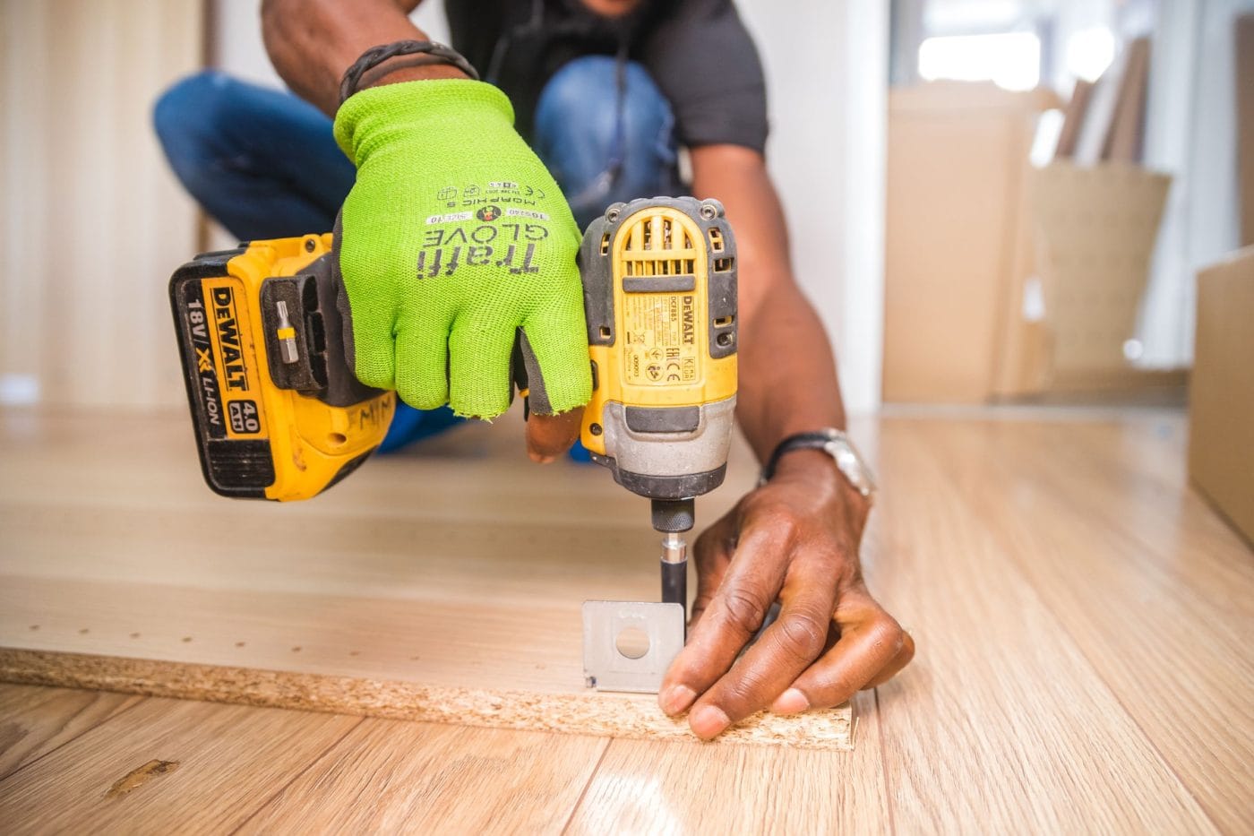 Technician driving a screw with a cordless drill during a repair