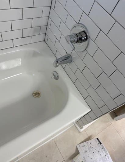 White subway-tile tub surround with new chrome hardware